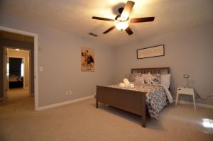 una camera da letto con un letto e un ventilatore a soffitto di The Cozy Pearl Townhome - 10 mins to horse park a Conyers Altre 29 foto