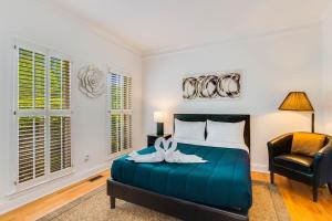 a bedroom with a blue bed and a chair at Serene Poolside Oasis 5 BR Office Luxe Amenities in Conyers +45 photos