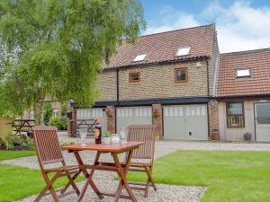 The Granary Thirsk Luxury Holiday Cottage Barn في ثيرسك: طاولة و كرسيين امام المنزل