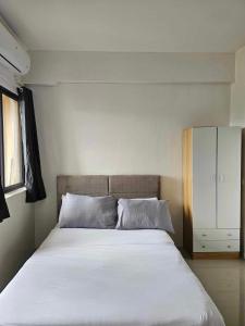 a bedroom with a large bed and a cabinet at Mabolo Garden Flats Bnb in Cebu City