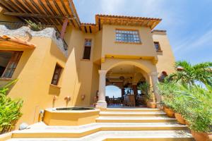 a yellow house with stairs leading up to it at Casa Ceiba Huatulco - Adults Only in Santa Cruz Huatulco
