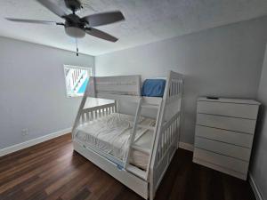 a white bunk bed in a room with a ceiling fan at Seaside Cove in Fort Pierce
