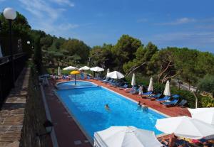 a pool with chairs and umbrellas and people in it at Residence Domus Cilento in Castellabate