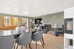 a dining room and living room with a table and chairs at KB - Nordic Lux Villa in Sørvågen
