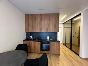 考纳斯Jaukus butas 2 kambariu girioje的配有木制橱柜、桌子和椅子的厨房