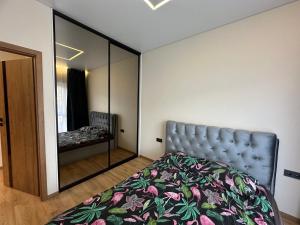 考纳斯Jaukus butas 2 kambariu girioje的带床和镜子的卧室