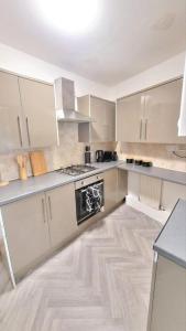 a kitchen with white cabinets and a stove top oven at Cozy 4-Bed House in Accrington in Accrington