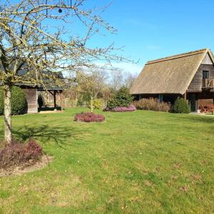 een huis met een grasveld met een boom bij Cottage du Becquet in Épaignes