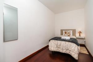a bedroom with a bed and a mirror at Atouguia House - Traditional House in Calheta