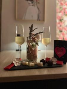 a table with two glasses of wine and a gift box at Suite Love Room Les Secrets d'Eden Rose- escapade romantique à 2 in Limoges