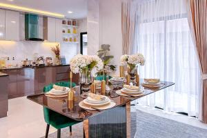 a dining room table with plates and flowers on it at Hidden Hill Pool Villa 4BR 15 Mins Jomtien Beach in Ban Huai Yai