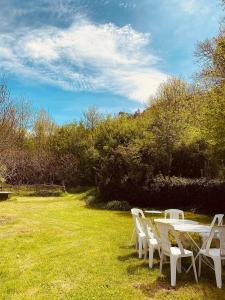 a group of white tables and chairs on a grass field at Le Moulin L'Official in Tulle