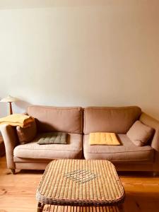 a living room with a brown couch with pillows at Le Moulin L'Official in Tulle