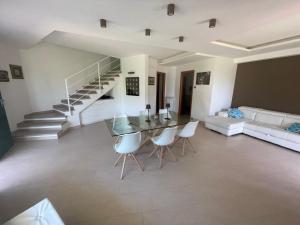 a living room with a glass table and white chairs at Villa Anzio in Anzio