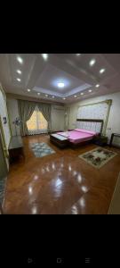 a large room with two beds and a wooden floor at رويل هيلز in 6th Of October