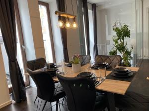 ein Esstisch mit schwarzen Stühlen drumherum in der Unterkunft SYMBIOSE-Ferienwohnung in München