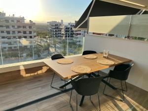 a dining room with a table and chairs and a large window at Claudia Luxury in Arenales del Sol