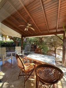 a patio with a table and chairs under a wooden roof at Villa hira in Eski Datca