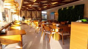 a dining room with wooden tables and chairs at Makia Beach Experience Muro Alto Porto de Galinhas in Ipojuca