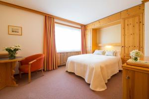 Postel nebo postele na pokoji v ubytování Hotel Europa Suites St Moritz