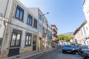 eine gepflasterte Straße in einer Stadt mit geparkten Autos in der Unterkunft Coruja’s House AL OPO in Porto