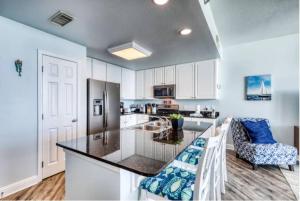 a kitchen with white cabinets and a black counter top at Lighthouse 1115 Condo on the beach 3BR 3BA in Gulf Shores
