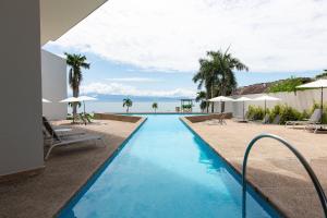 a swimming pool with a view of the ocean at Beachfront|Pool|Gym Beautiful Studio Zantamar 303D in Cruz de Huanacaxtle