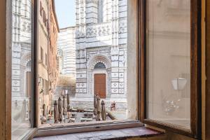 an open window with a view of a cathedral at Il Battistero Siena Residenza d'Epoca in Siena