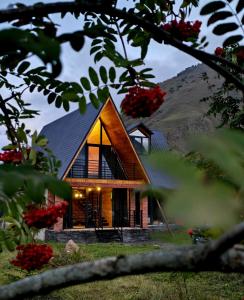a house on a hill with the lights on at Grand Mountain Cottage in Stepantsminda