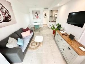 salon z kanapą i telewizorem w obiekcie Chocolate Brownie Piscina, Terraza, Planta baja, parking y WIFI w Corralejo