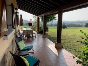 eine Terrasse mit Stühlen und einem Tisch und Blick auf ein Feld in der Unterkunft La Cabaña de Meruelo in San Miguel de Meruelo