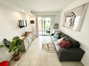 salon z kanapą i telewizorem w obiekcie Chocolate Brownie Piscina, Terraza, Planta baja, parking y WIFI w Corralejo
