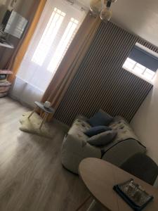 a living room with a couch and a table at Studio Cosy à Orange in Orange +5 photos