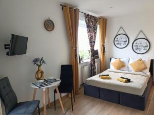 a bedroom with a bed and a table and a tv at Royal EvitaBocelli Spodek by walk self check - in in Katowice