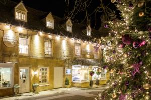 a christmas tree in front of a building with lights at The Old Stocks Inn in Stow on the Wold +13 photos