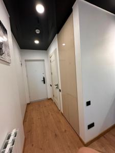 a hallway with white walls and white doors and wooden floors at Next apartments "Seaside" in Batumi +2 photos
