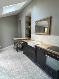 a kitchen with a sink and a counter with a mirror at Appartement 1 - La Maison Augustine in Hem +25 photos