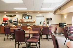 une salle d'attente avec des tables, des chaises et un comptoir dans l'établissement Days Inn by Wyndham Thunder Bay North, à Thunder Bay