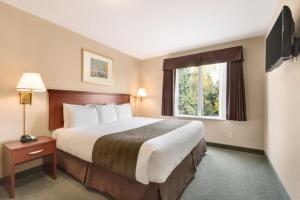 Un pat sau paturi într-o cameră la Days Inn by Wyndham Thunder Bay North