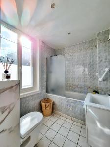 a bathroom with a tub and a toilet and a sink at Chantilly Garden in Gouvieux +15 photos