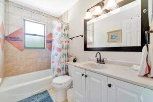 ein Badezimmer mit Waschbecken, Toilette und Spiegel in der Unterkunft Blissful Beach Retreat Super in Englewood + 43 Fotos