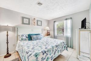 ein Schlafzimmer mit einem Bett, einem Fernseher und einem Fenster in der Unterkunft Blissful Beach Retreat Super in Englewood