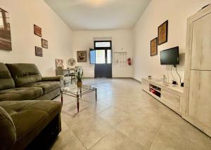 a living room with a couch and a tv at Gens Fulvia Brindisi in Brindisi