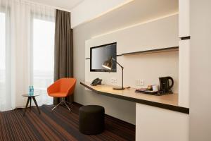 a hotel room with a desk and a chair at Hyperion Hotel Hamburg in Hamburg