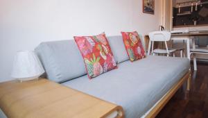 Un sofá azul con dos almohadas y una mesa. en Italianway-Cesare da Sesto, en Milán