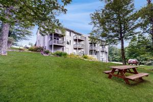 un tavolo da picnic sull'erba di fronte a un edificio di Skyleaf E4 a Sugar Mountain