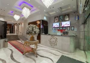 a lobby with a counter with a vase of flowers at فندق دار الريس - Dar Raies Hotel in Makkah
