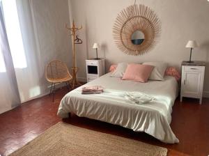 a bedroom with a bed with a mirror on the wall at Mas Bérenger in Beaumes-de-Venise