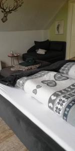 a bed in a living room with a couch at Landhaus Löwenzahn in Dornum