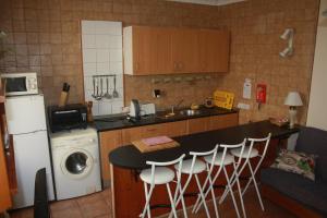 uma cozinha com um balcão, um lavatório e uma máquina de lavar louça em Governor's Inn Apartments em Gibraltar